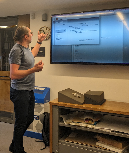 Mark Rogerson standing next to a computer monitor displaying the EE website